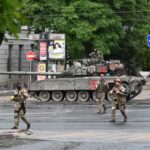 Fighters of Wagner private mercenary group cross a street as they get deployed near the headquarters of the Southern Military District in the city of Rostov-on-Don, Russia, June 24, 2023. REUTERS/Stringer